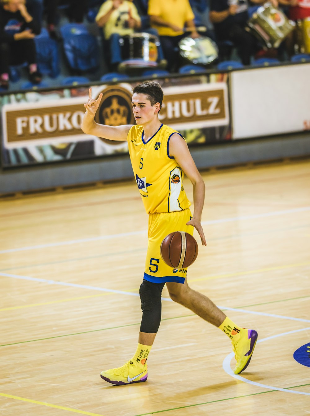 man in yellow jersey shirt playing basketball