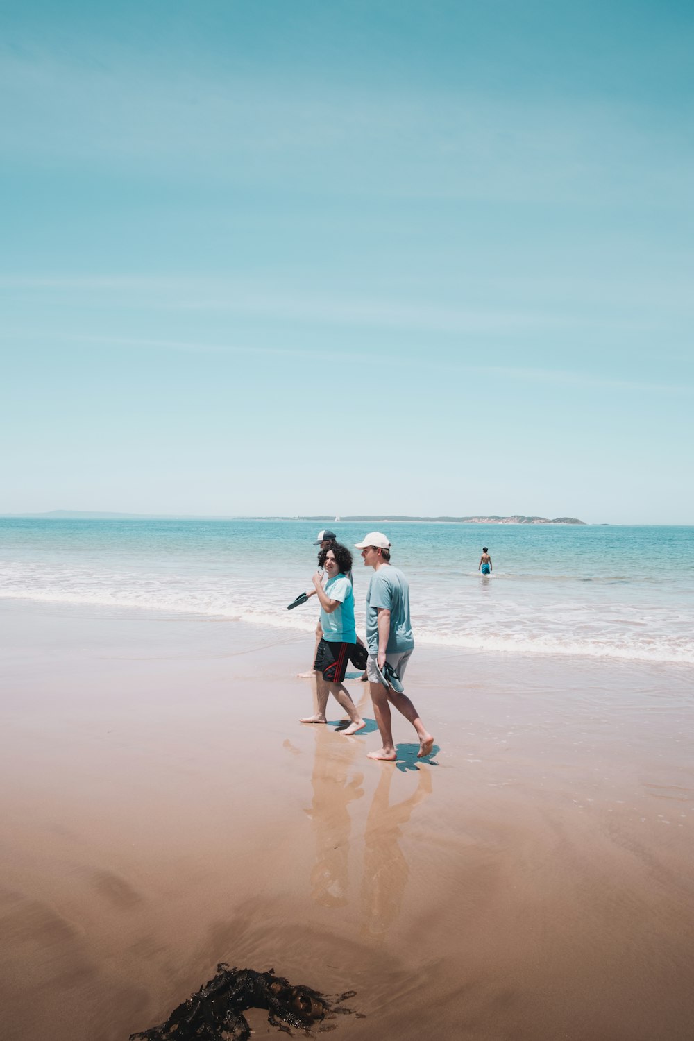 hombre y mujer caminando en la playa durante el día