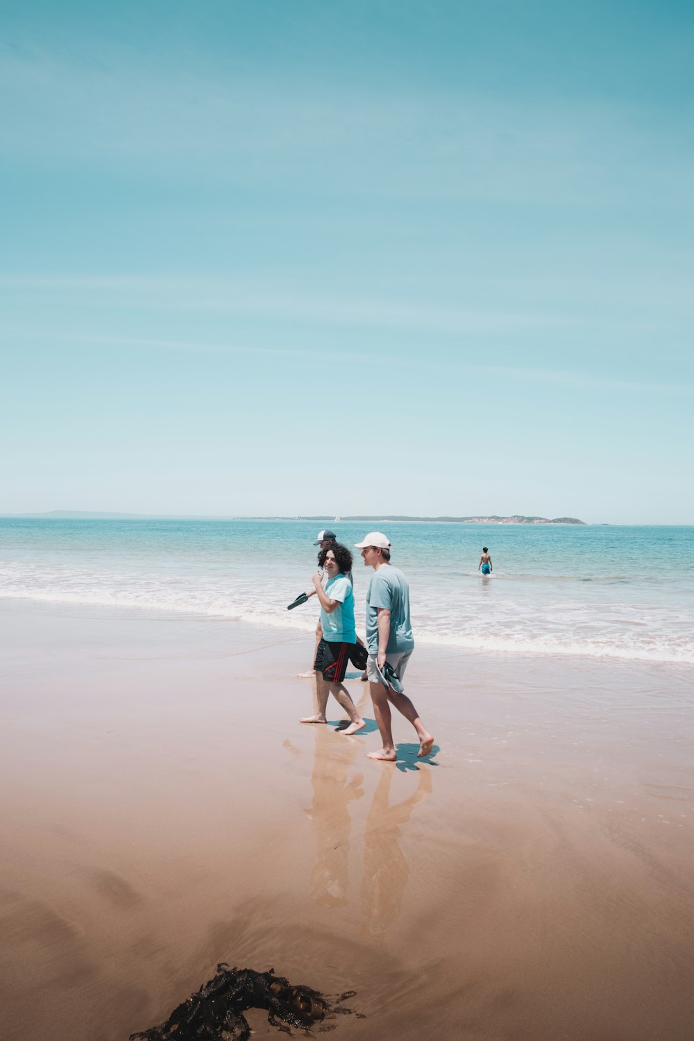 man and woman walking on beach during daytime