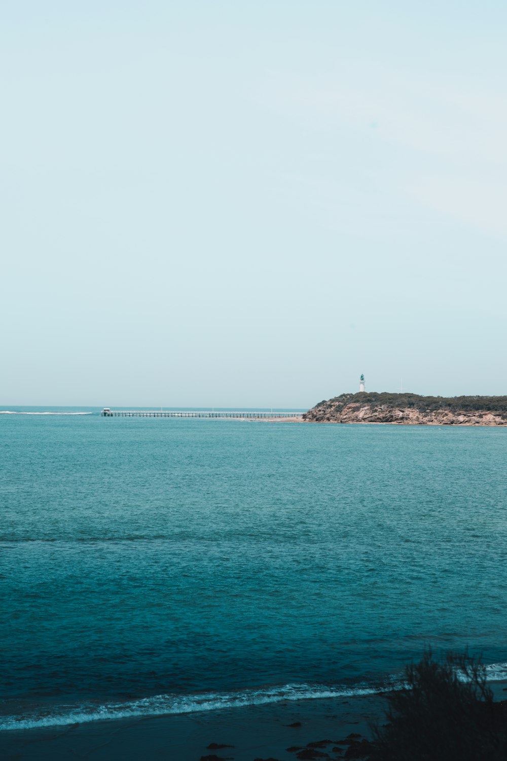 body of water under white sky during daytime