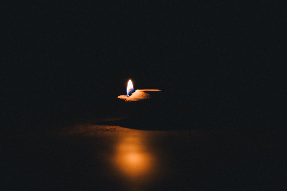 Brennende Kerze auf braunem Holztisch