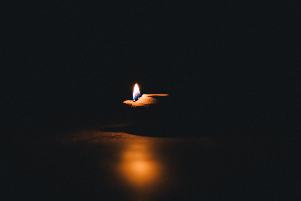 lighted candle on brown wooden table