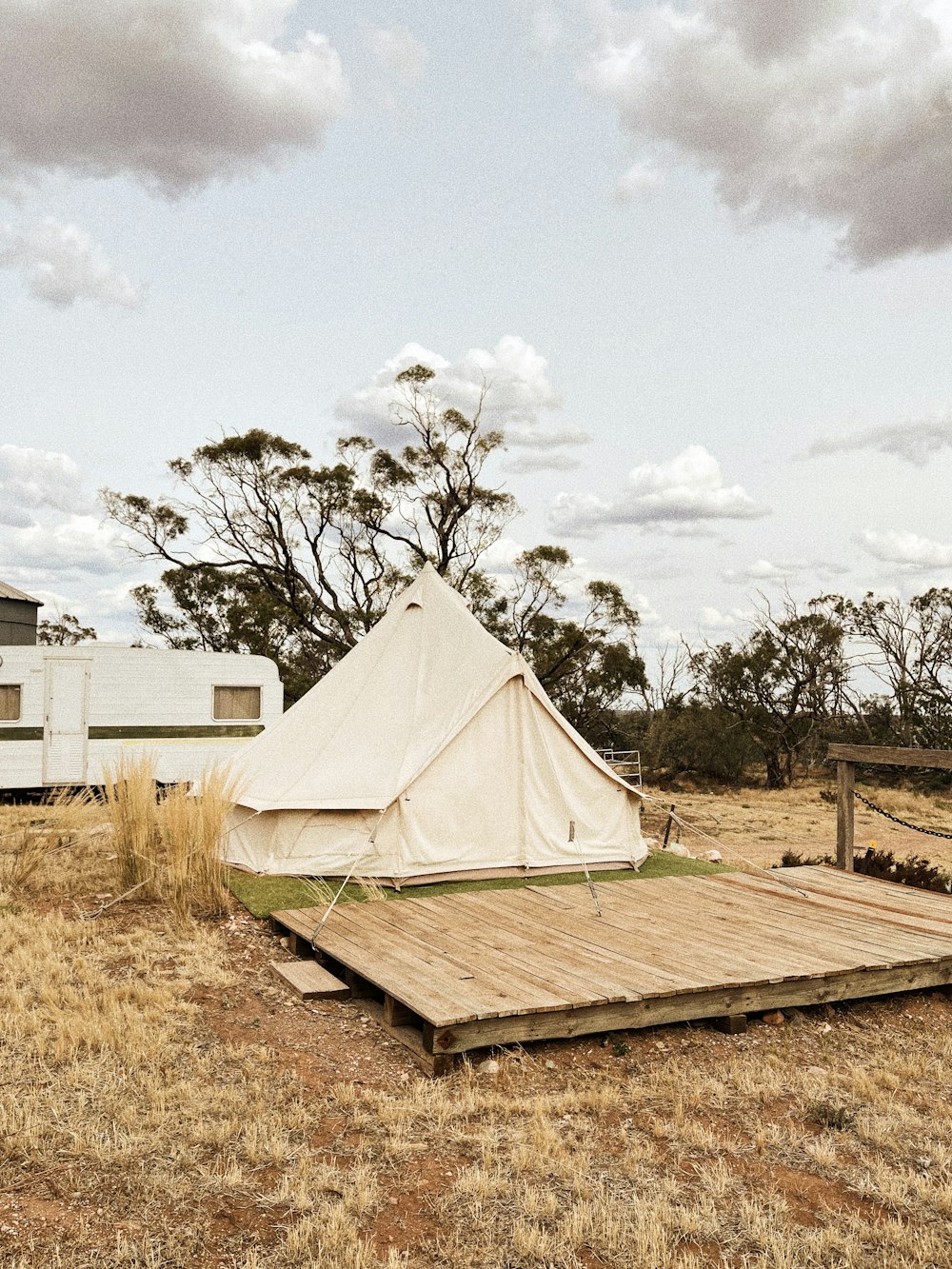 white tent on green grass field under white cloudy sky during daytime