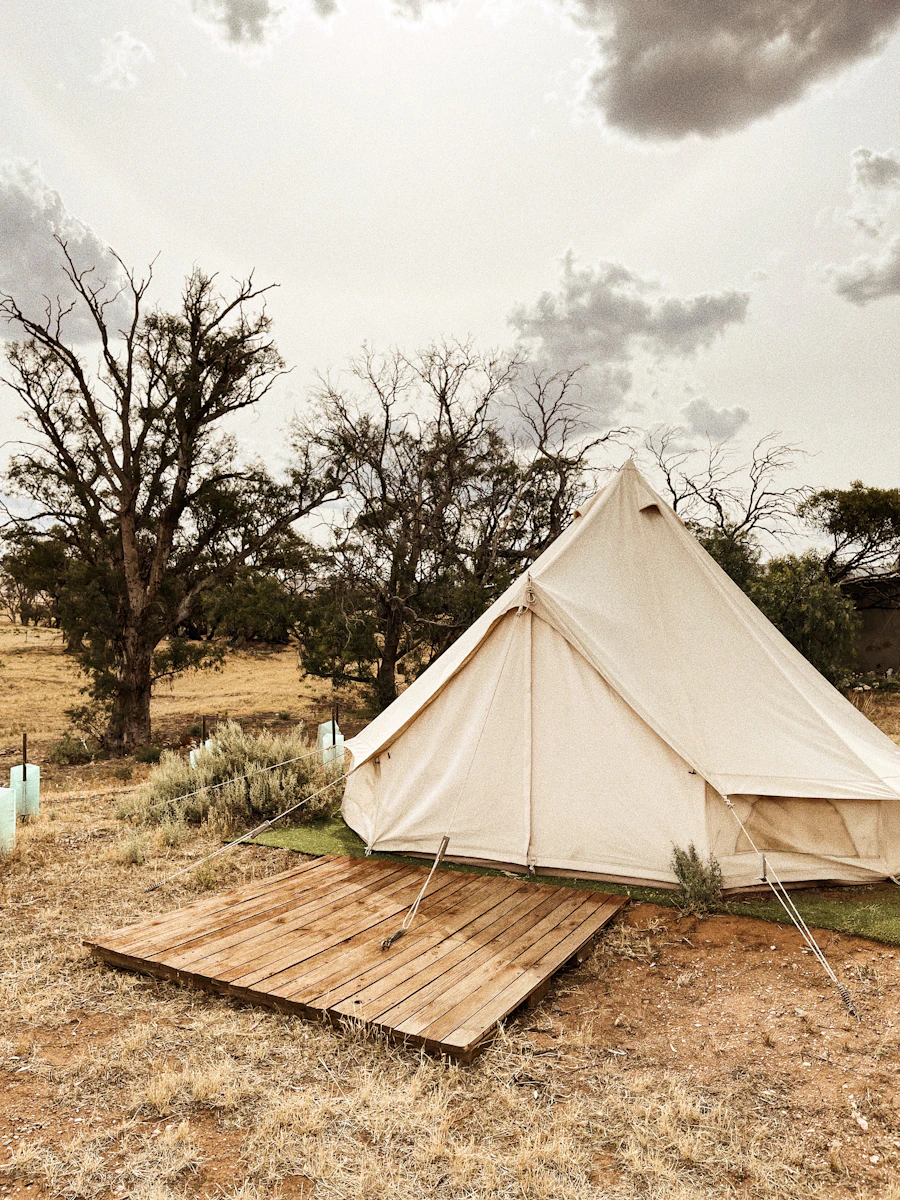 A glamping bell tent with wooden deck in an open landscape