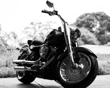 A sleek black motorcycle parked against a dark asphalt background with subtle military green details.