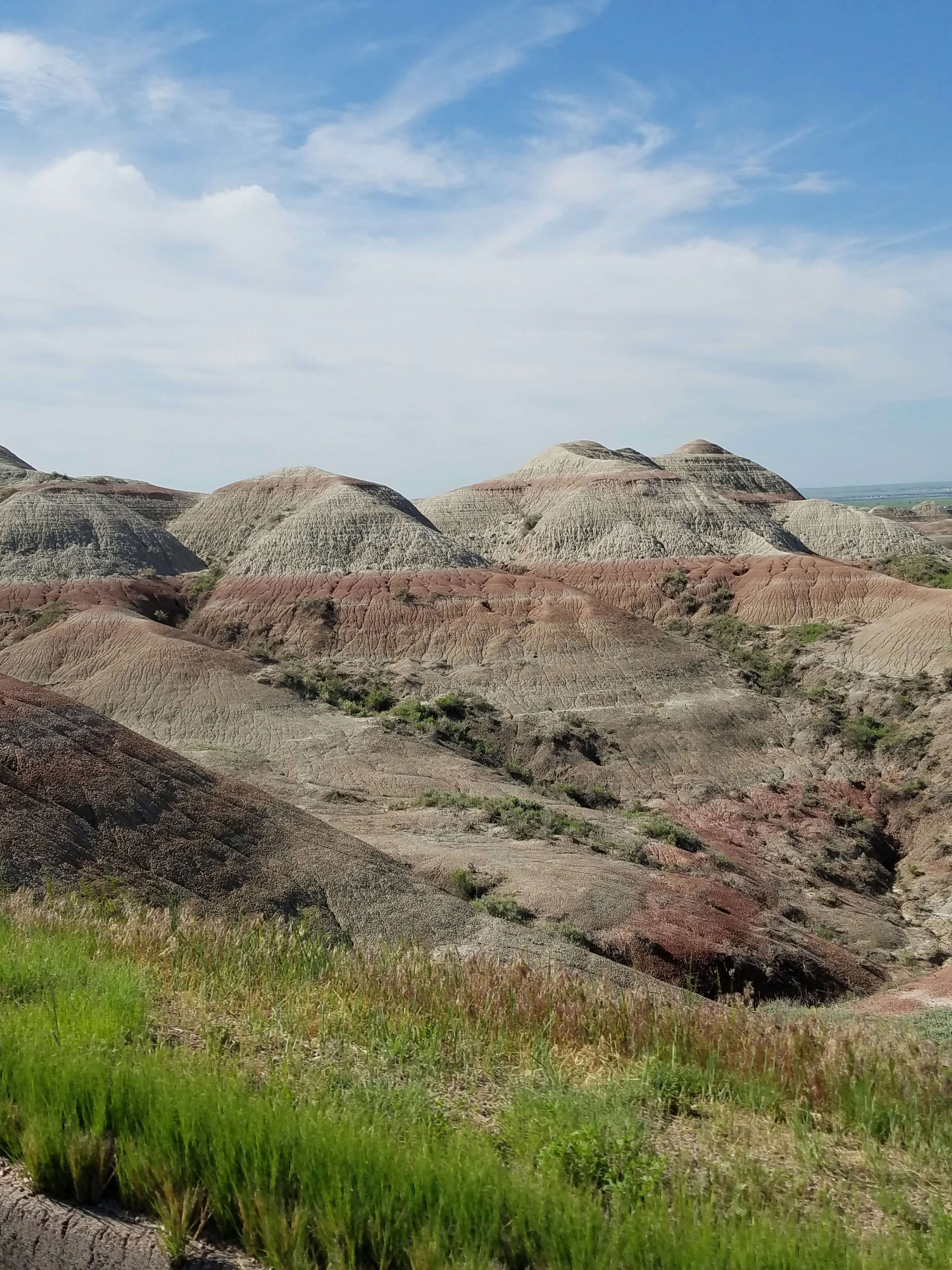 brown and gray mountains under white clouds and blue sky during daytime
