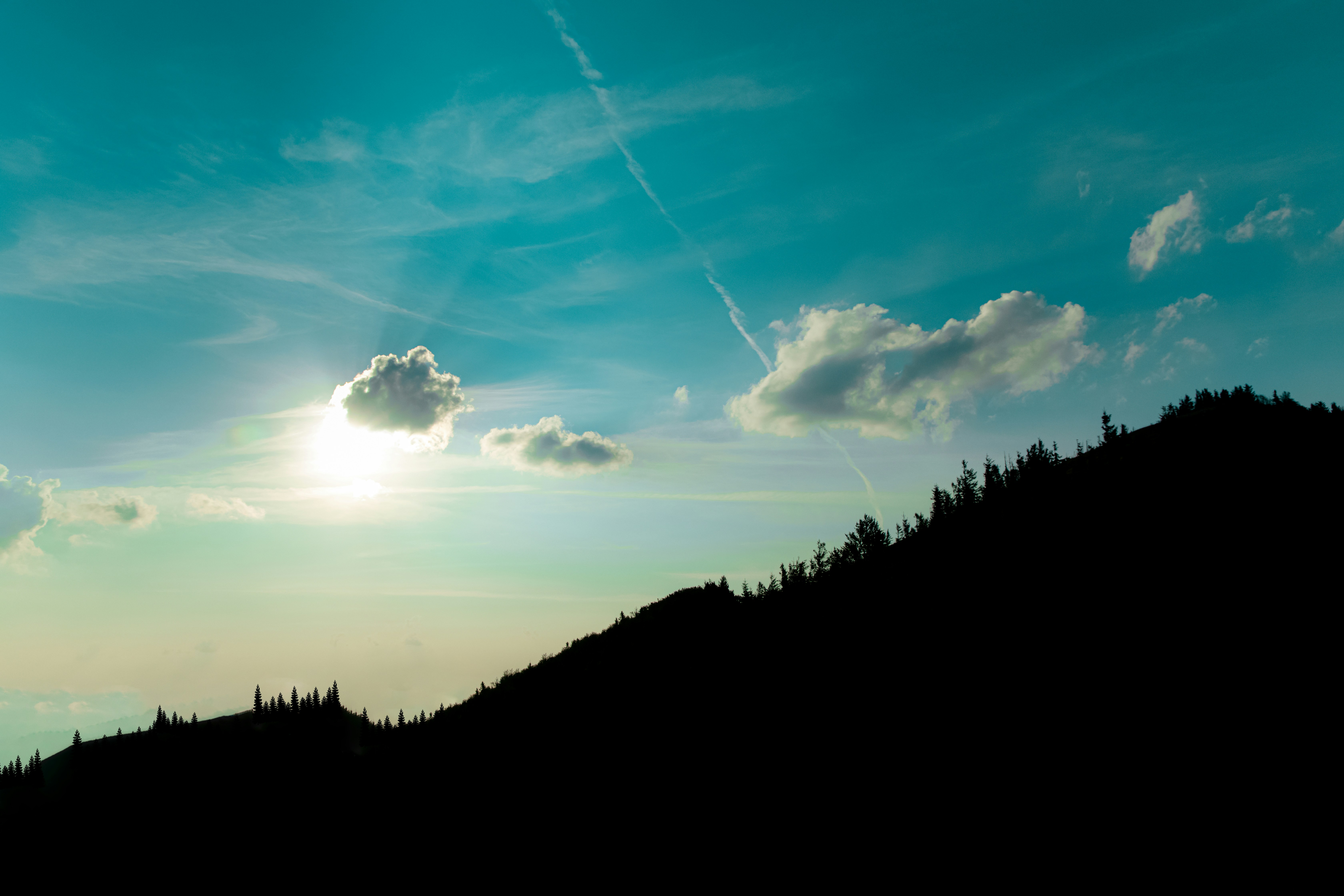 beautiful dramatic mountain silhouette landscape scenic view evening blue sky background with sun light rays behind cloud wallpaper concept of nature photography with empty copy space