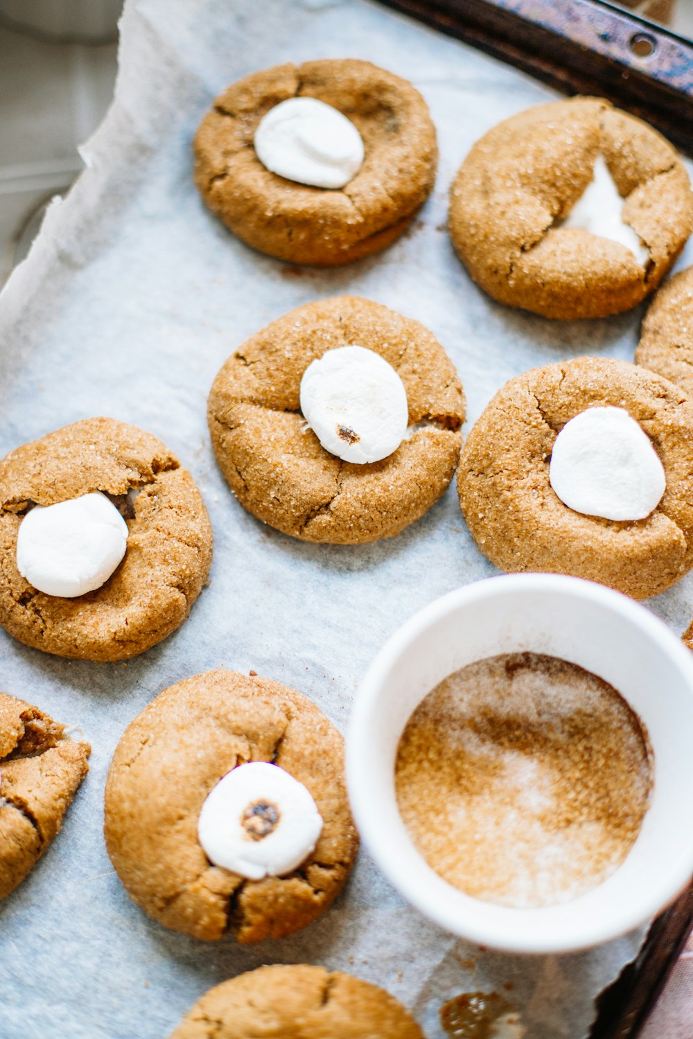 white ceramic mug with coffee beside cookies