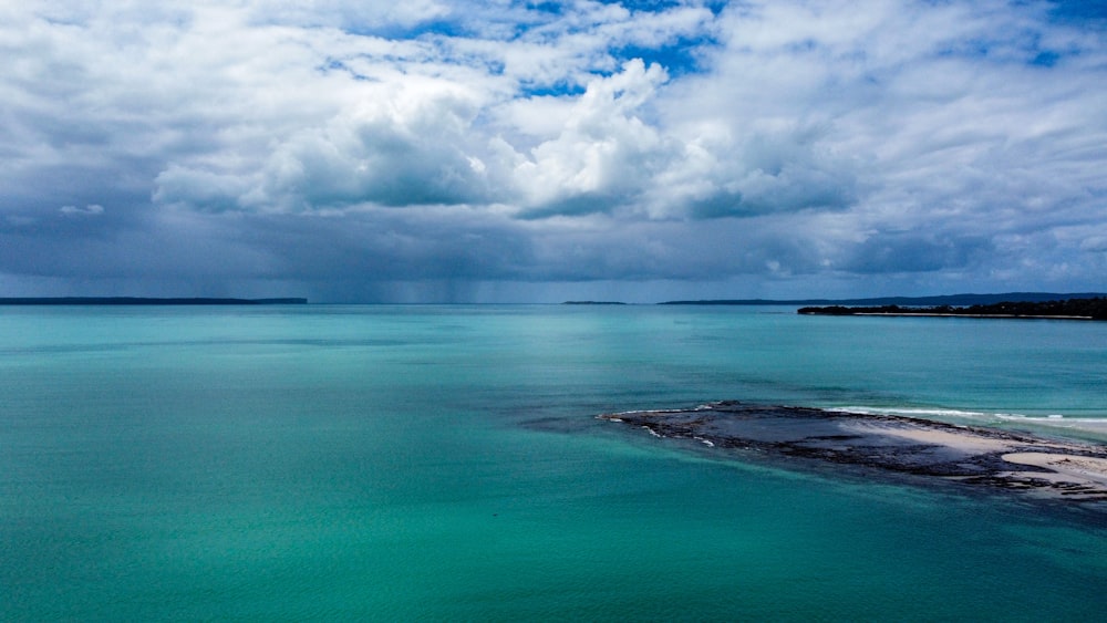 blue sea under white clouds and blue sky during daytime