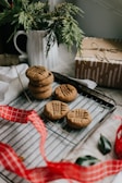 A cozy kitchen scene with a baker’s hands gently placing fresh cookies on a cooling rack.
