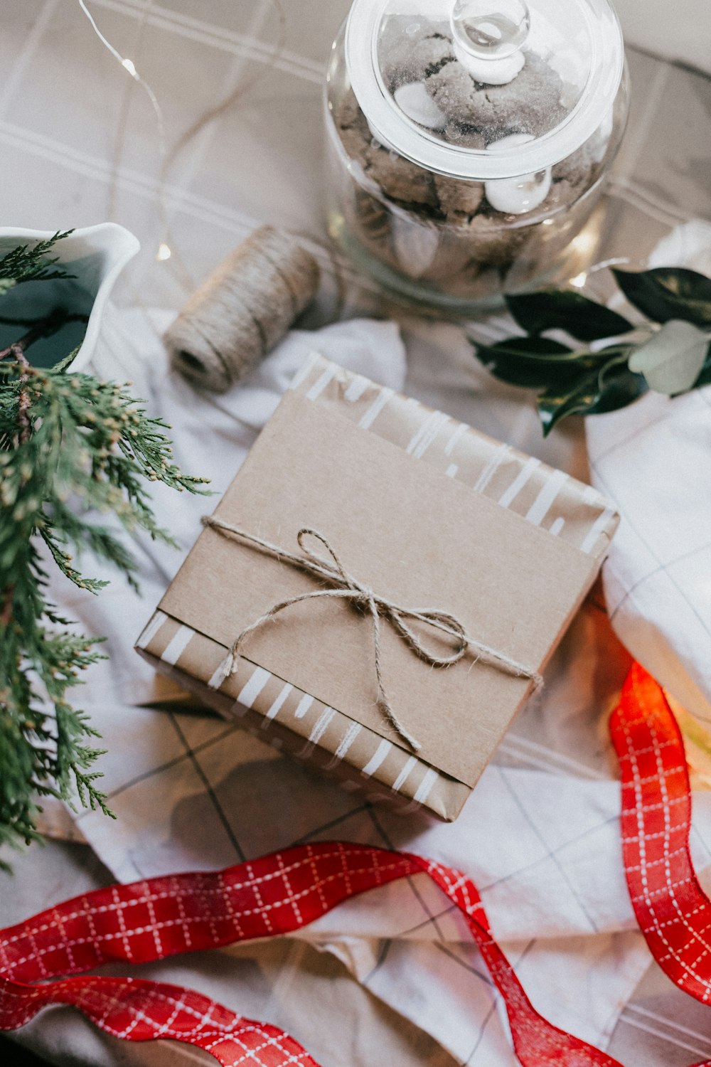 Caja de regalo marrón sobre textil de cuadros blancos y rojos