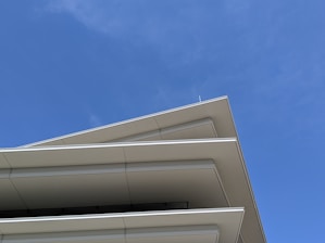 A commercial building with a freshly repaired roof under a clear blue sky.