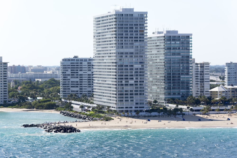 people on beach near high rise buildings during daytime