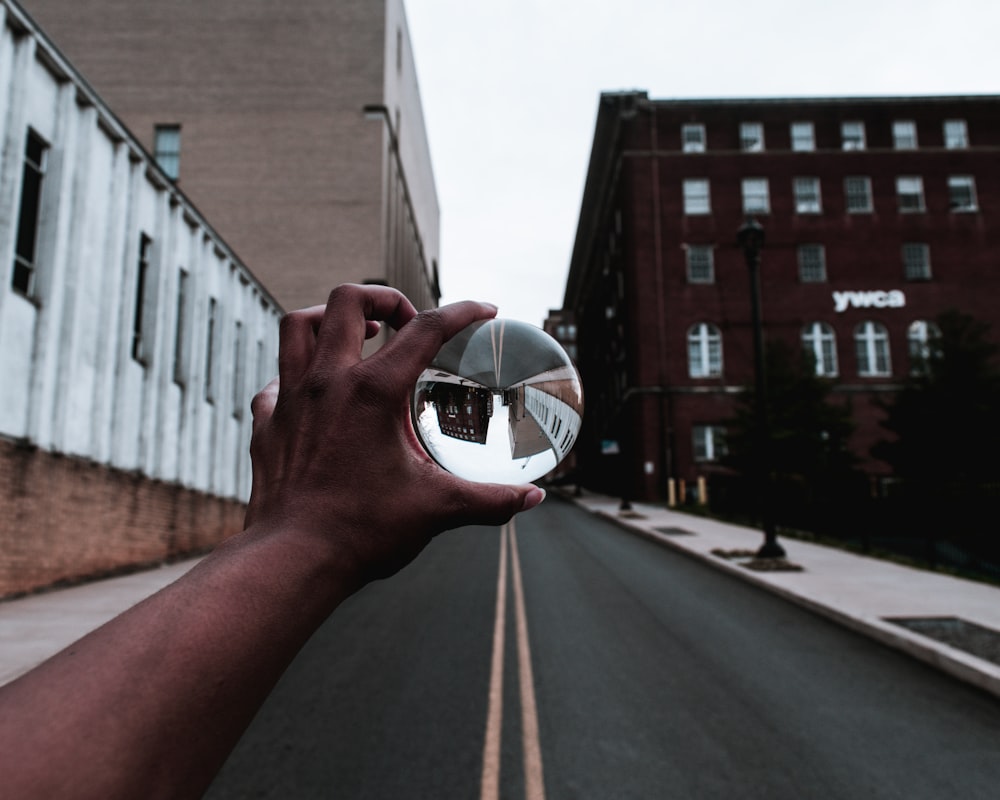 person holding white and black soccer ball