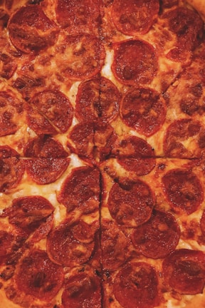 Close-up of pepperoni sizzling atop a perfectly baked pizza with bubbly cheese.