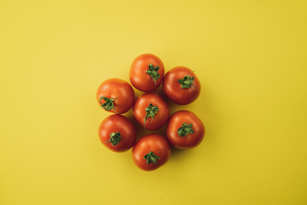 red tomato on yellow surface
