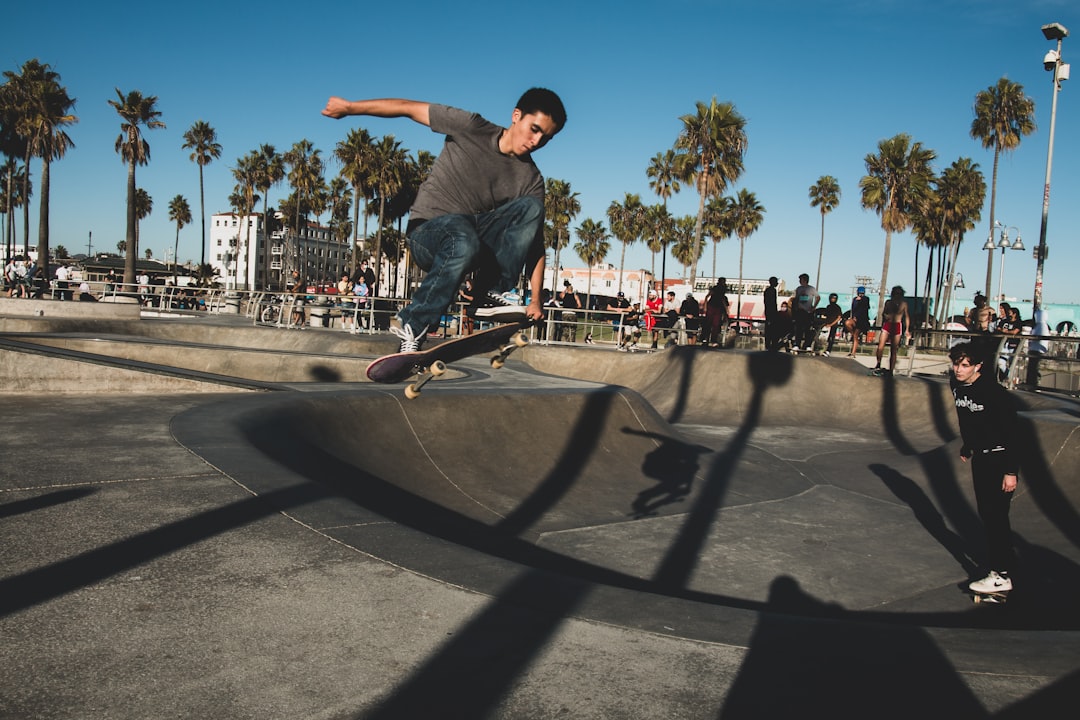 man in blue denim jeans and black shirt riding skateboard during daytime