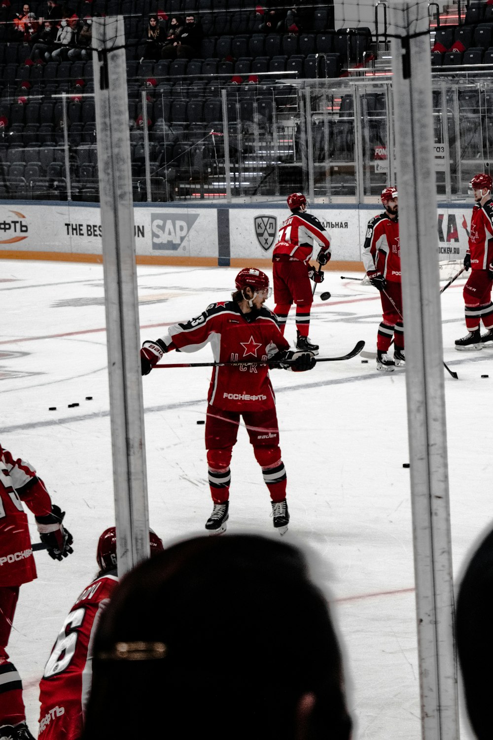 Uomini in maglia rossa da hockey su ghiaccio che giocano a hockey su ghiaccio