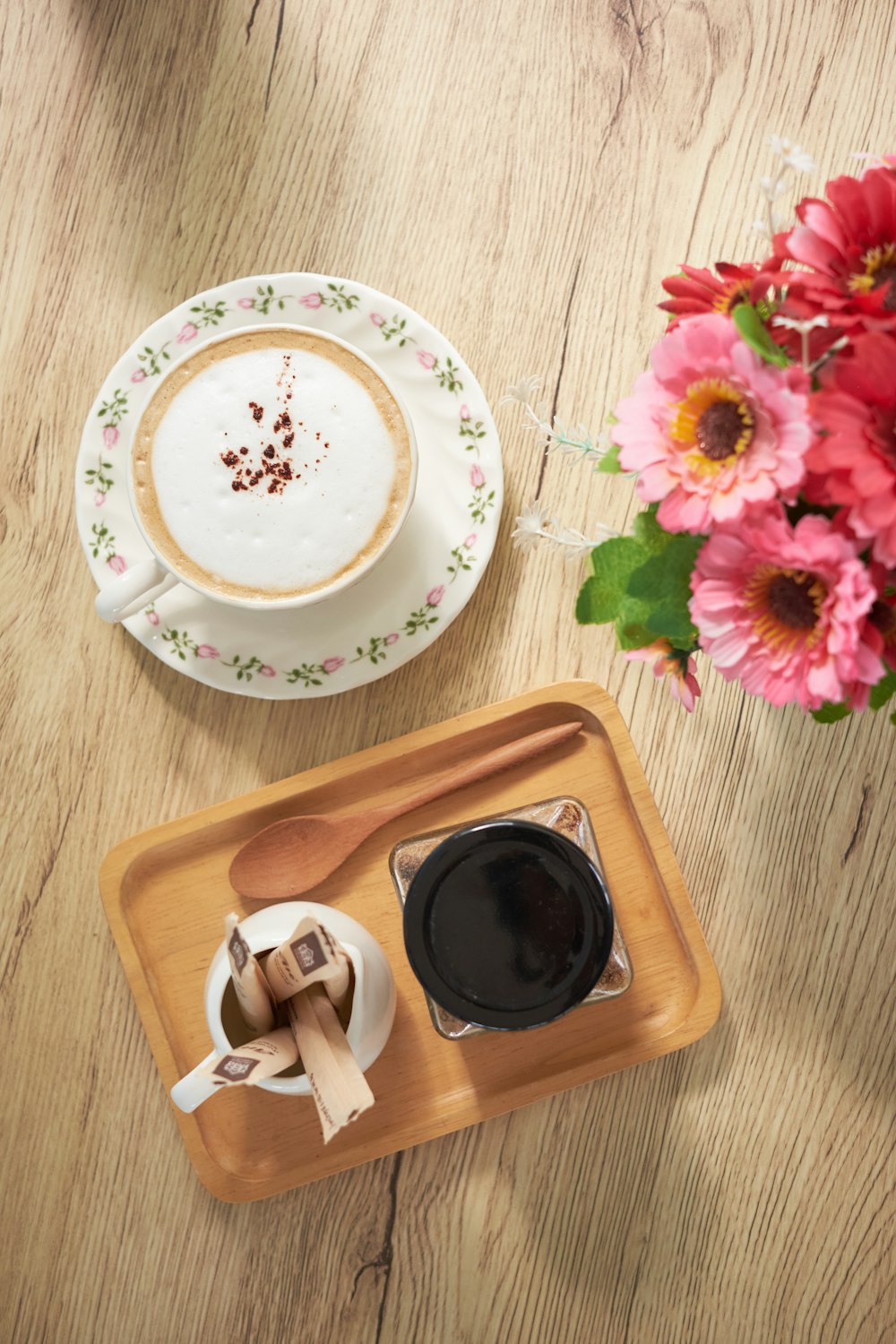 white and pink floral ceramic plate on brown wooden tray