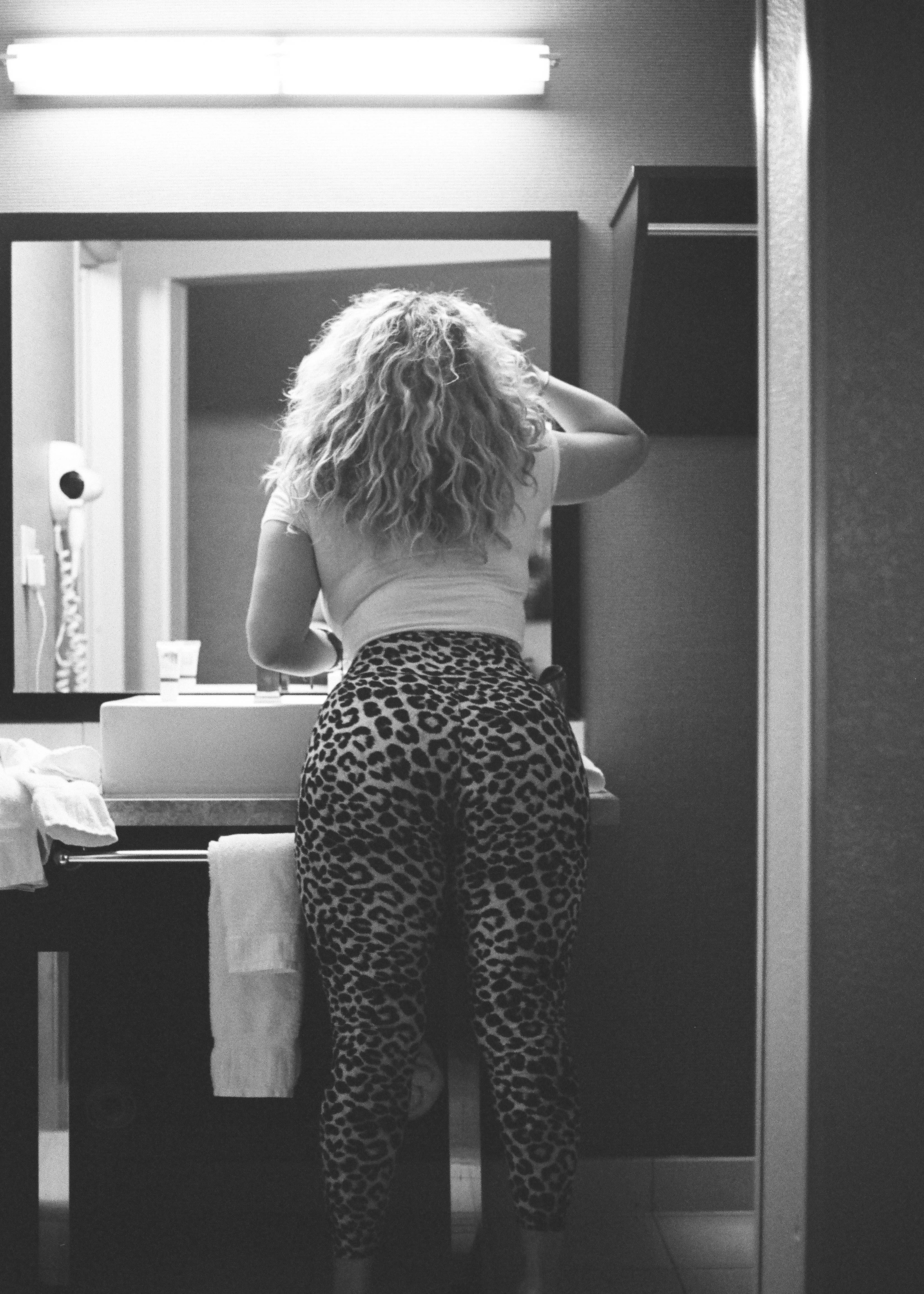woman in black and white pants standing in front of mirror
