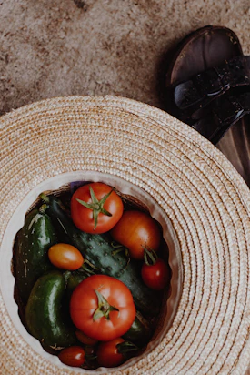 red and green tomato on brown woven round basket