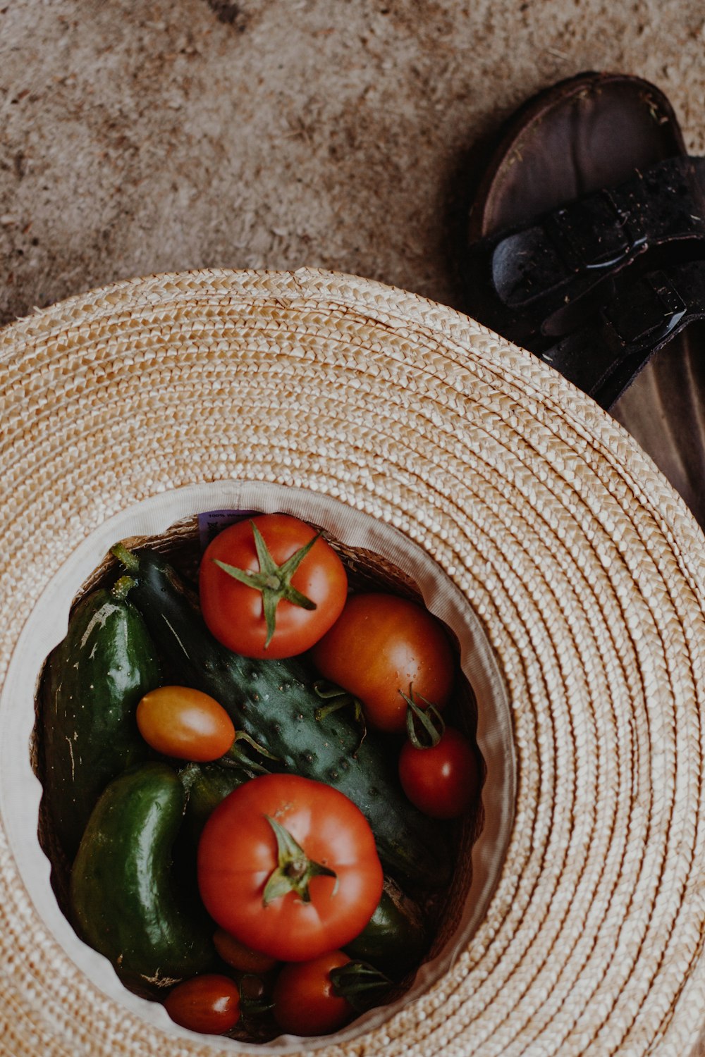 red and green tomato on brown woven round basket