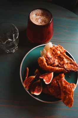 A plate of freshly baked pastries next to a glass of iced coffee on a sunny afternoon.