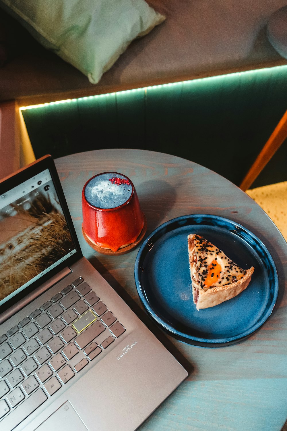 pizza on blue plate beside red can on table