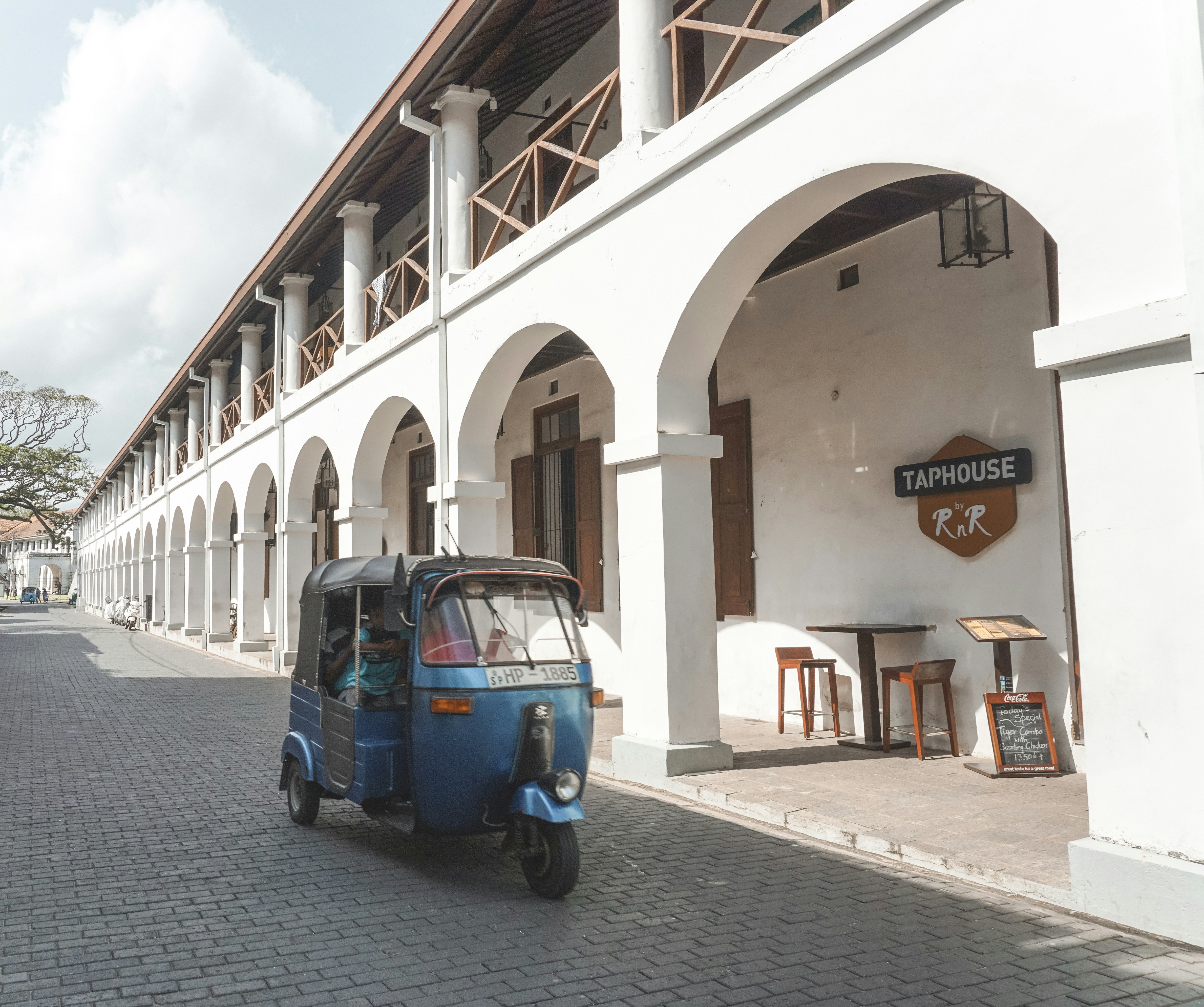 blue car parked beside white concrete building during daytime