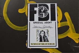 A poster-like image of an FBI special agent identification card with the name Dana Scully. The card features an official seal and a black-and-white photo of a woman with shoulder-length hair. Below the photo is a quote: 'The truth is out there, but so are lies.' The background includes yellow graffiti-like markings.
