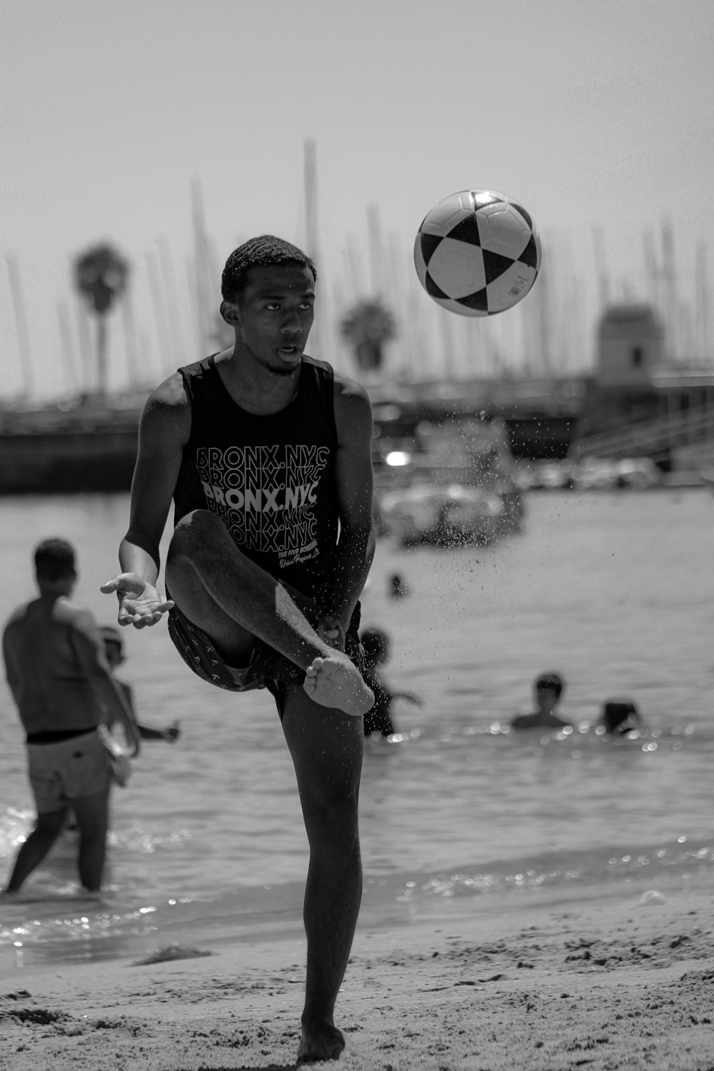 man in black tank top playing soccer in grayscale photography