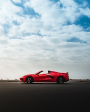 red ferrari 458 italia on brown sand under white clouds during daytime