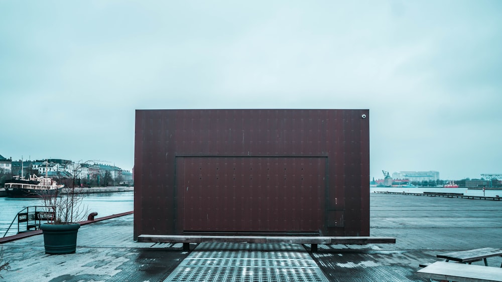 brown wooden building near body of water during daytime