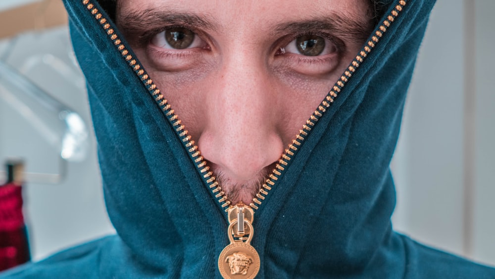 person wearing gold necklace with gold pendant