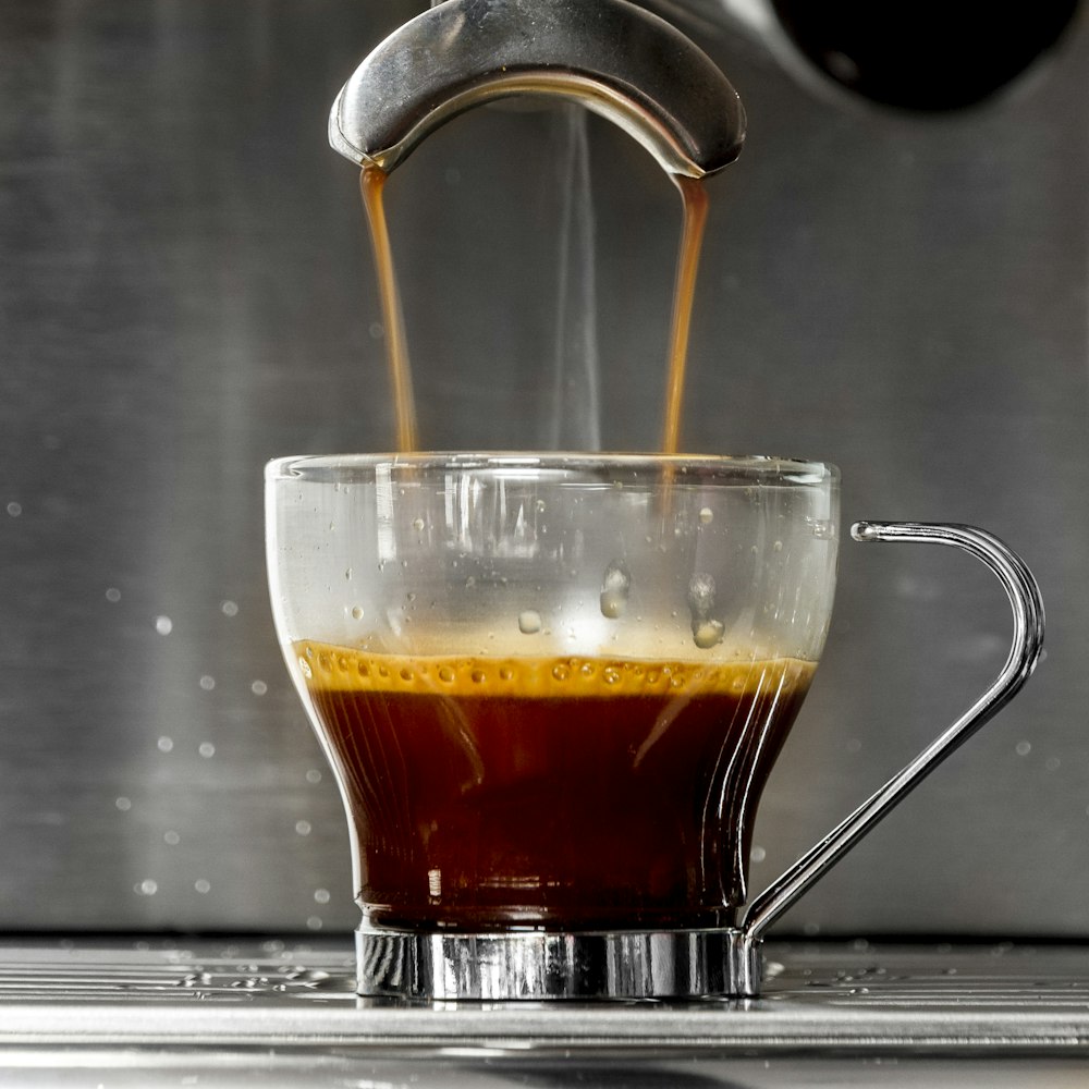 clear glass mug with brown liquid