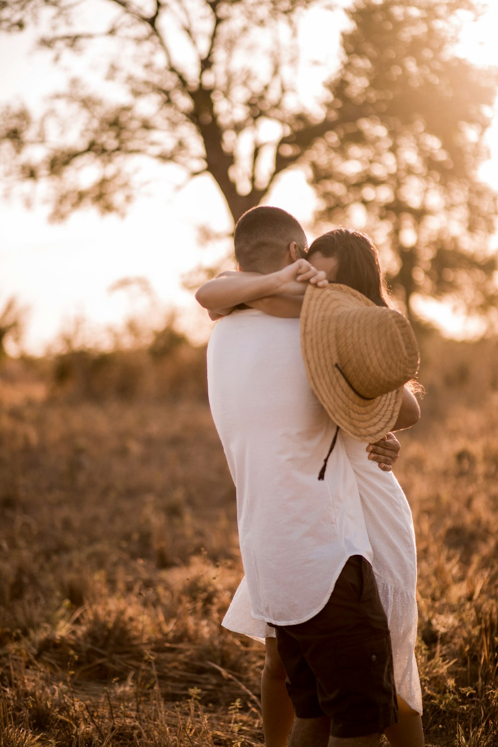 man in white shirt carrying woman in white dress during daytime