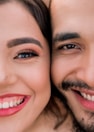man and woman smiling while taking selfie