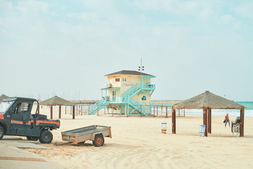 white and blue wooden lifeguard house on beach shore during daytime