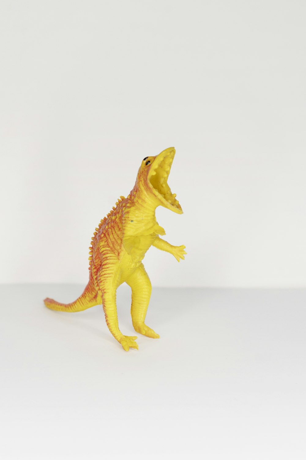 黄色とオレンジ色の恐竜のおもちゃ
