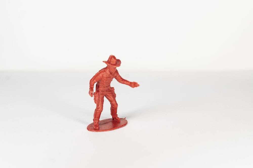 red plastic toy on white surface