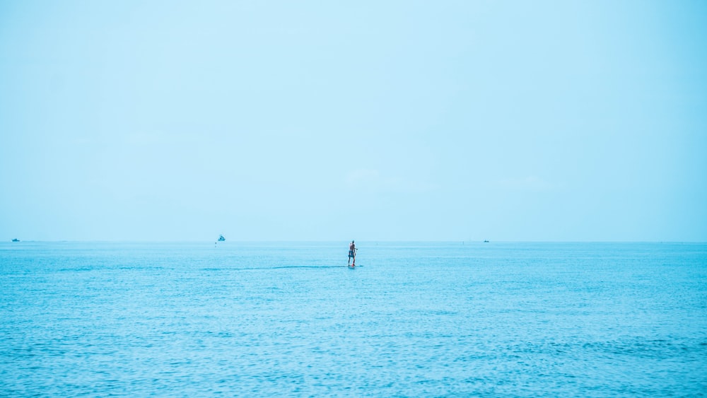2 people standing on sea during daytime