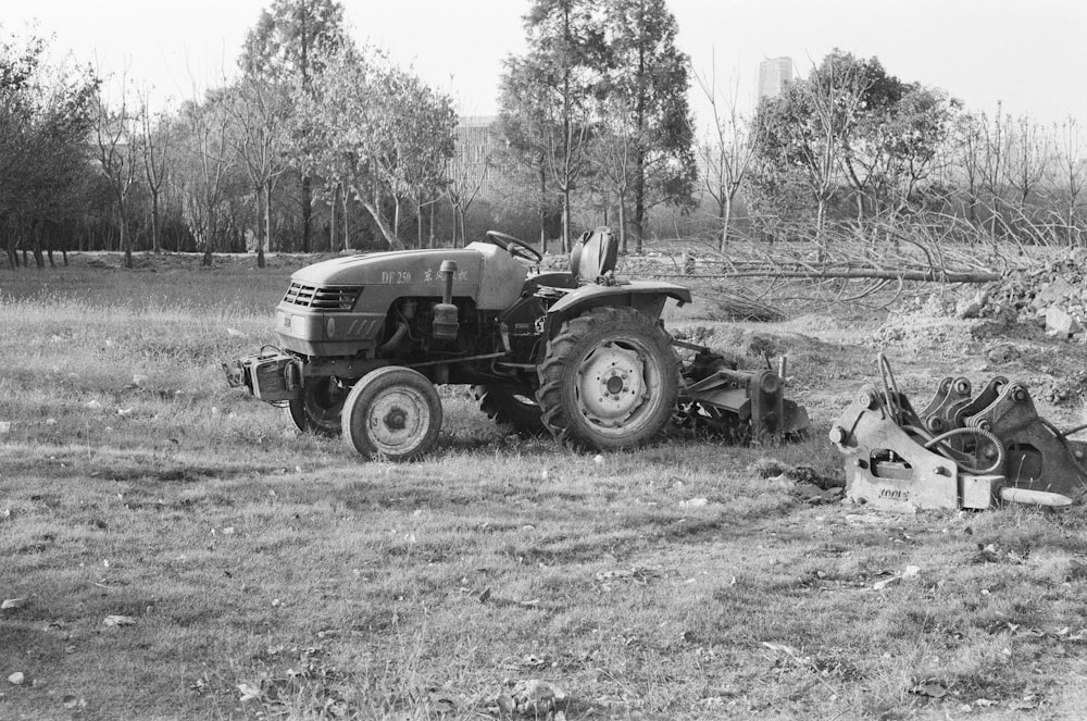 grayscale photo of tractor on grass field