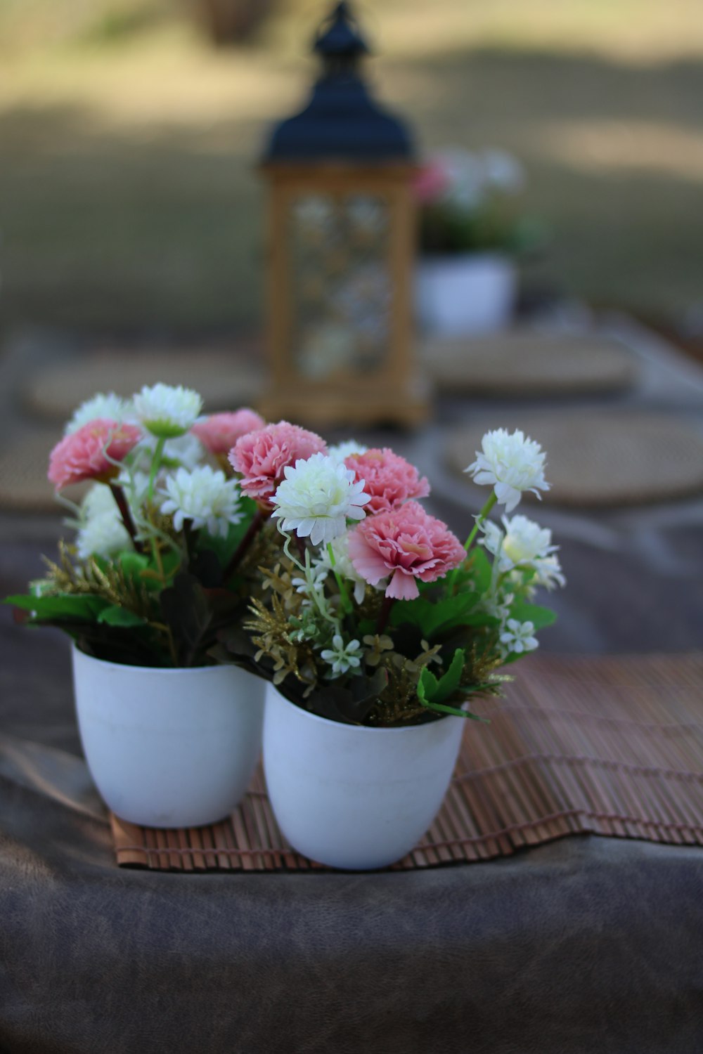 rosa und weiße Blumen in weißer Keramikvase