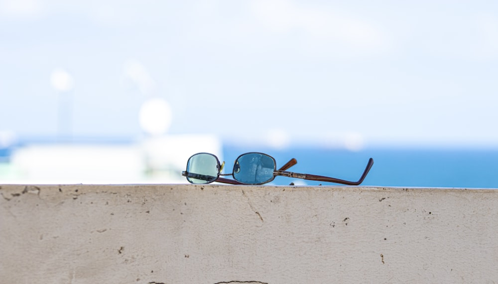 black framed sunglasses on brown wooden surface