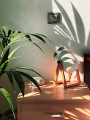 A compact solar lamp placed on a wooden table, perfect for indoor or outdoor use.