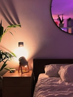 Bedroom with gentle pastel green walls and elegant bedside lamps glowing warmly.