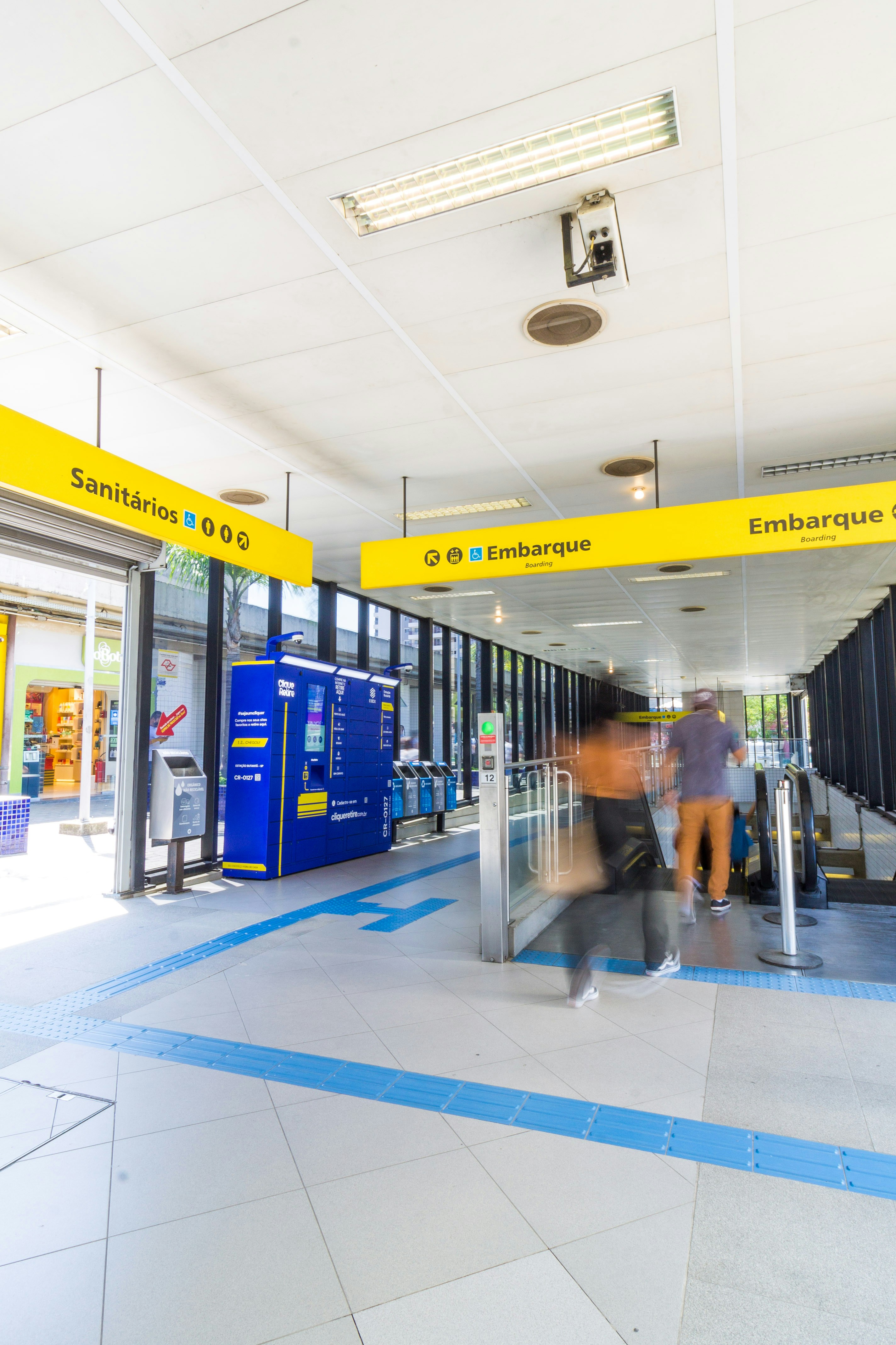 homem na jaqueta azul de pé perto do trem azul e amarelo