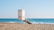 white wooden lifeguard house on beach during daytime