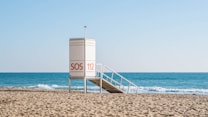 white wooden lifeguard house on beach during daytime