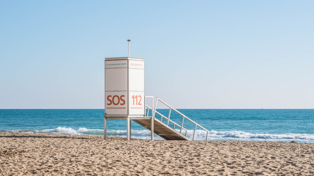 white wooden lifeguard house on beach during daytime